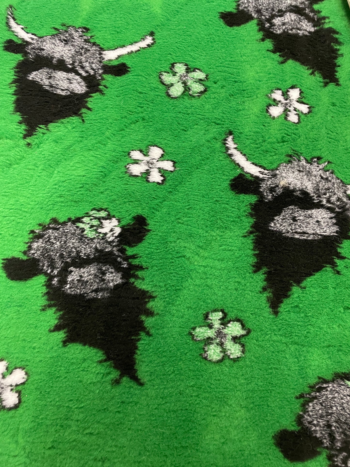 Green vet bedding with Highland cow design for dogs and puppies close up