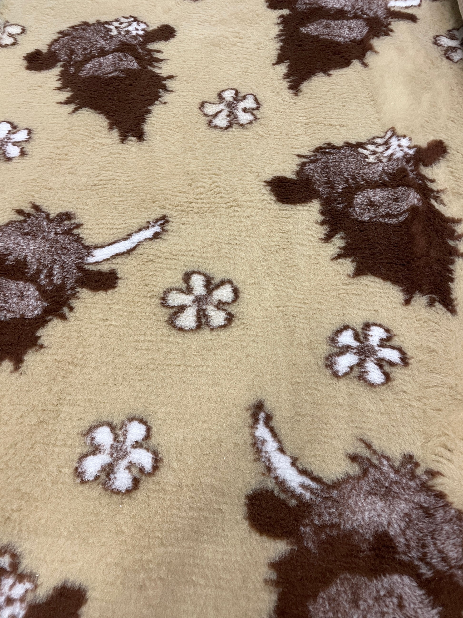 Beige vet bedding with Highland cow design for dogs and small puppies close up