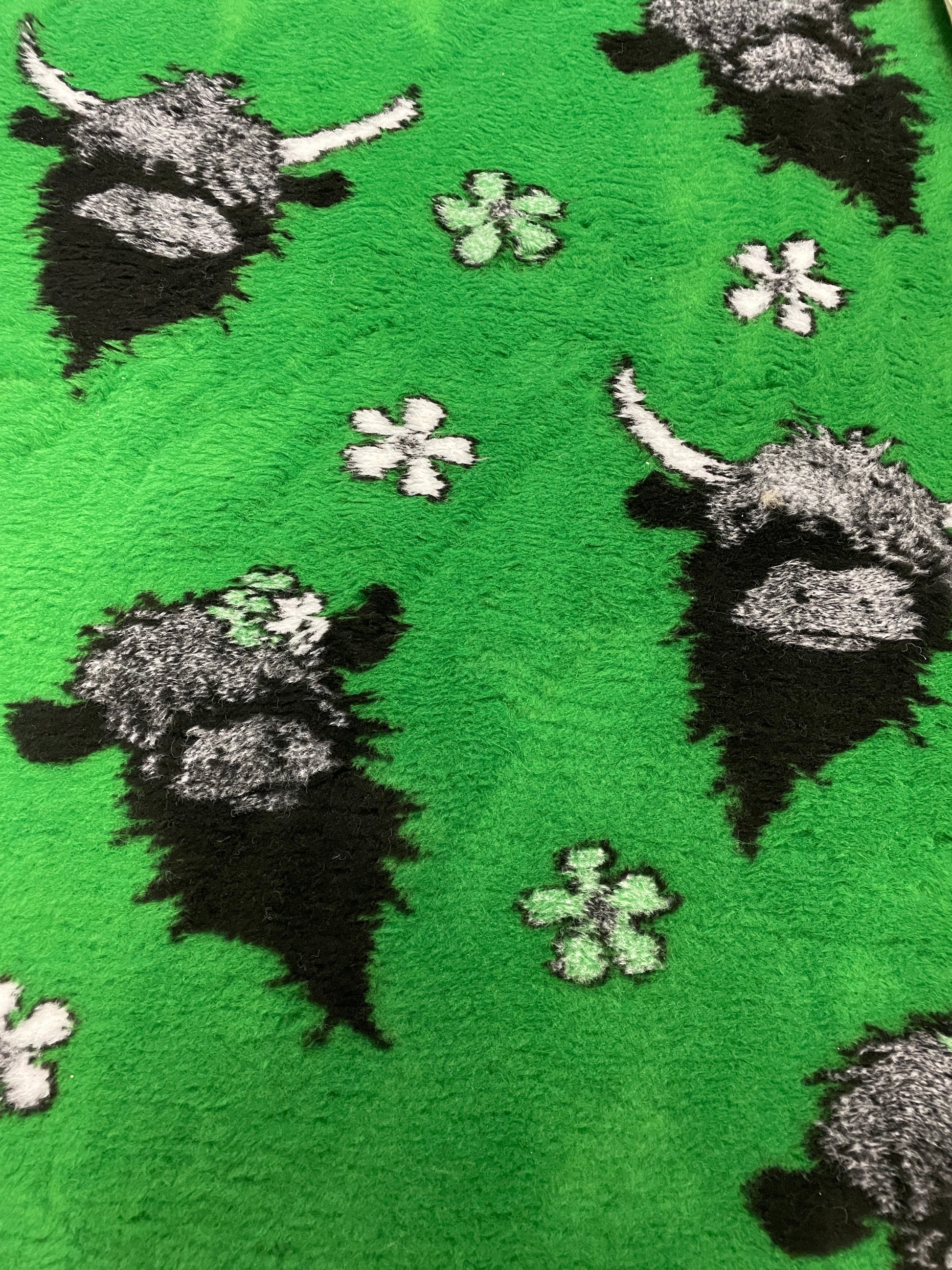 Green vet bedding with Highland cow design for dogs and puppies close up